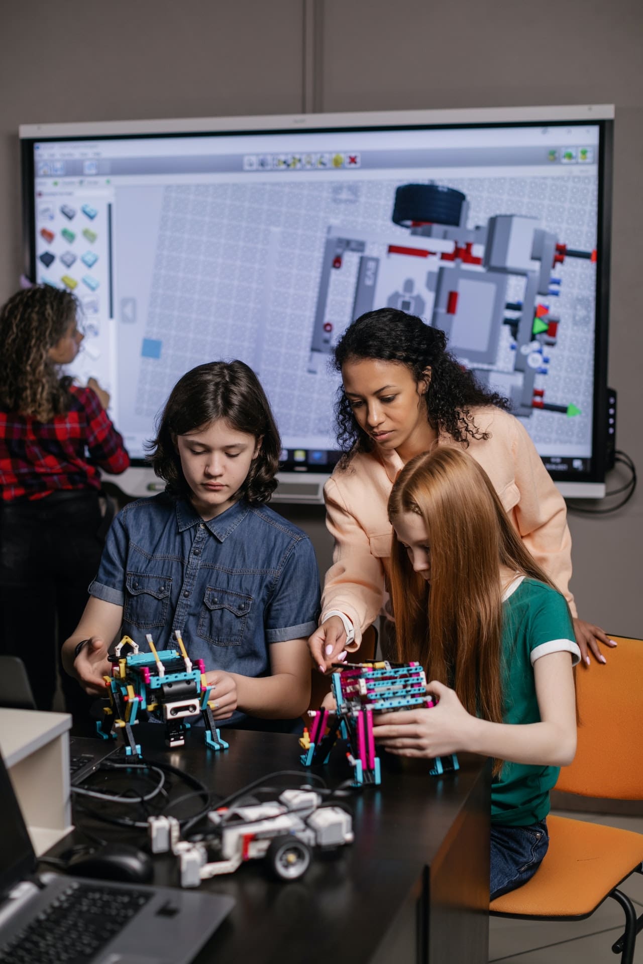 children building lego robots with a summer camp instructor.